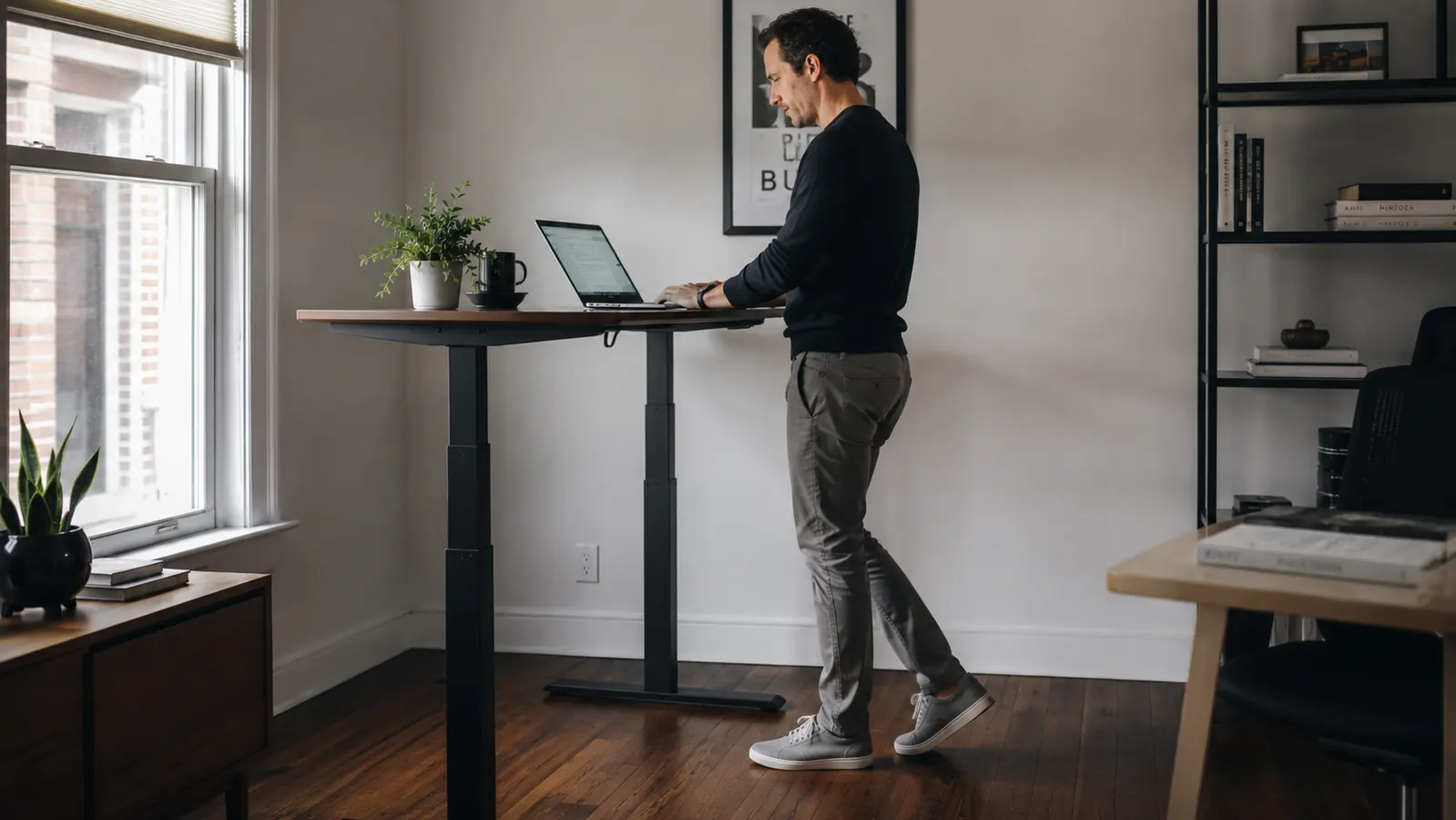 Walking pad folded upright and leaned against a home office wall next to a bookshelf